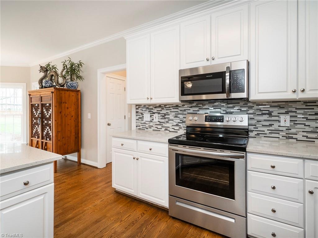 2811 Norwell Court Oak Ridge, NC 27310 - Photo 12 of 50 Kitchen offers ample amount of cabinet and drawer space. Stainless steel stove, microwave and dishwasher are brand new!