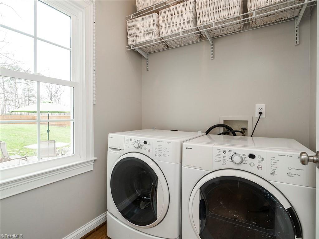 2811 Norwell Court Oak Ridge, NC 27310 - Photo 17 of 50 Laundry room is off the kitchen, offers shelving storage and natural light through the window overlooking the backyard.