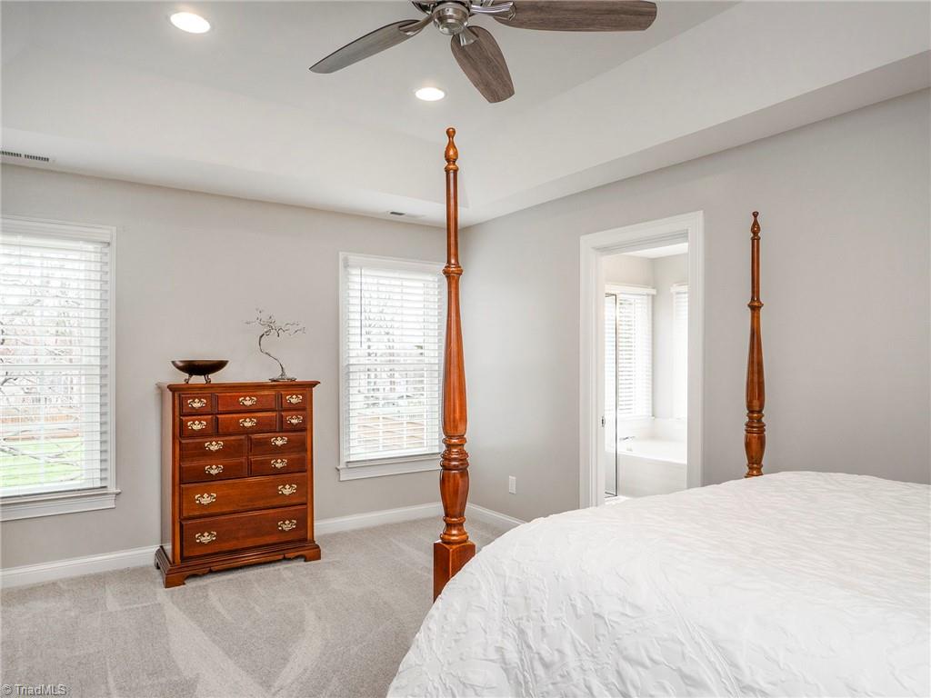 2811 Norwell Court Oak Ridge, NC 27310 - Photo 23 of 50 Spacious primary with views of the gorgeous backyard, updated ceiling fan, tray ceiling and beautifully updated bath