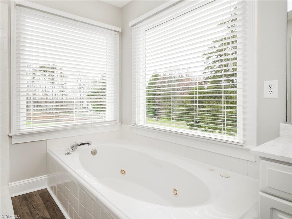 2811 Norwell Court Oak Ridge, NC 27310 - Photo 25 of 50 Jetted tub with views of backyard, features panoramic corner windows which look out into the treetops
