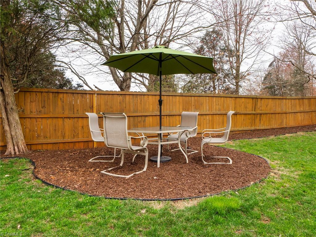 2811 Norwell Court Oak Ridge, NC 27310 - Photo 42 of 50 Shaded circular mulched area in backyard can be used as an additional seating area, a trampoline area or a level area for an above-ground pool.