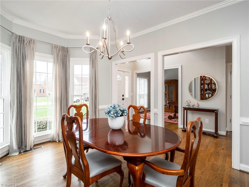 2811 Norwell Court Oak Ridge, NC 27310 - Photo 6 of 50 Large dining room with gorgeous oversized pella bay windows offer beautiful morning sun. Chair railing and crown molding.