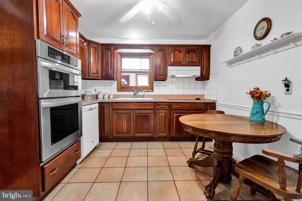a kitchen with stainless steel appliances granite countertop a stove a sink dishwasher and cabinets
