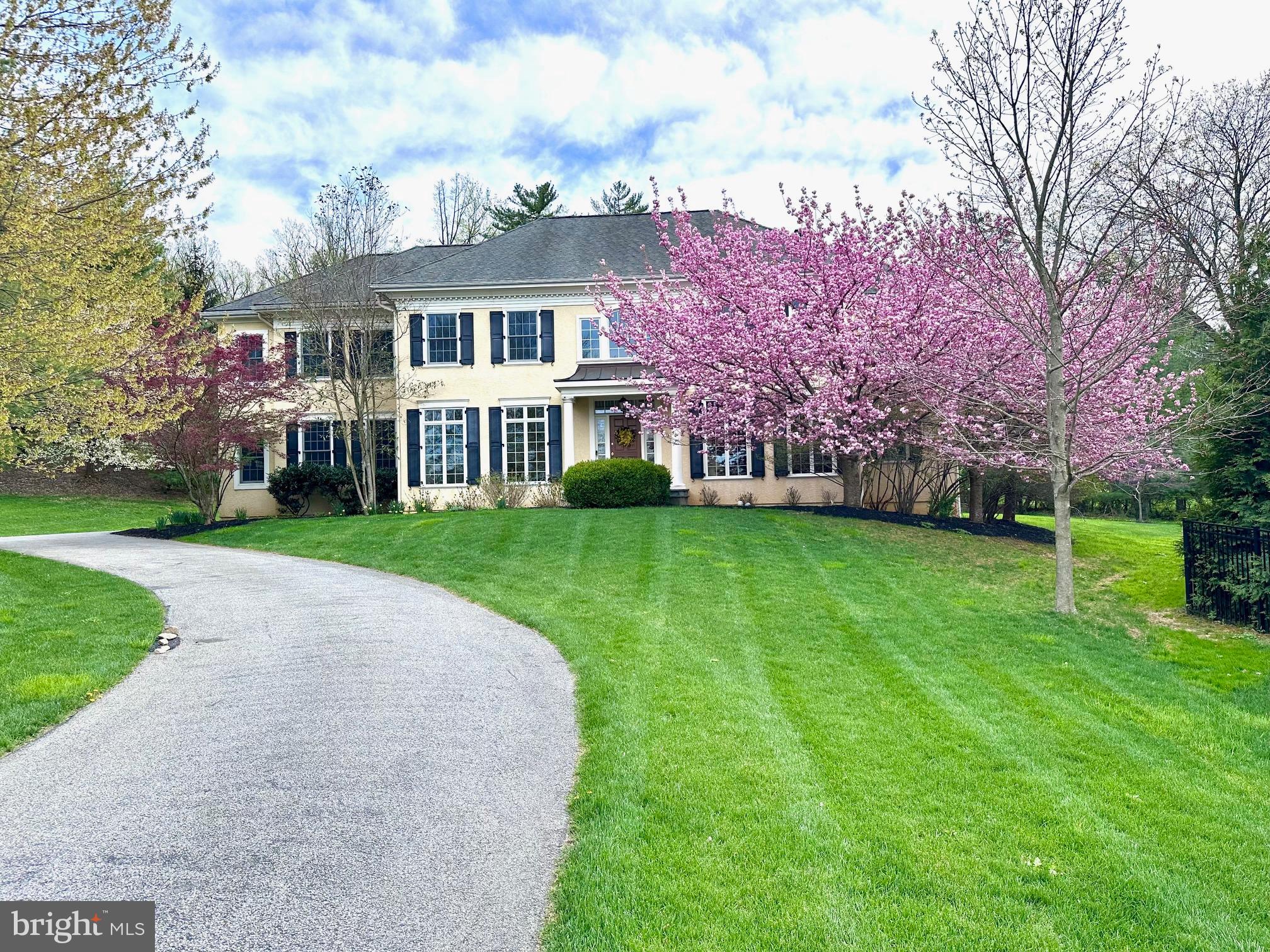 a view of a house with a big yard and large trees