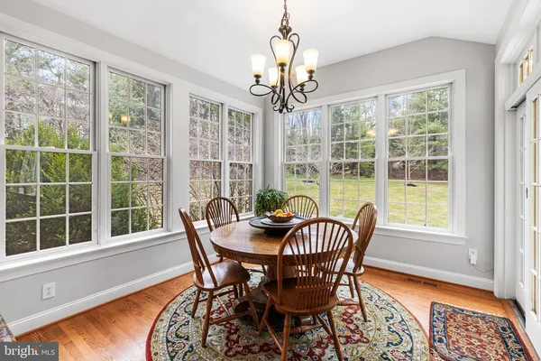 a dining room with furniture a chandelier and wooden floor