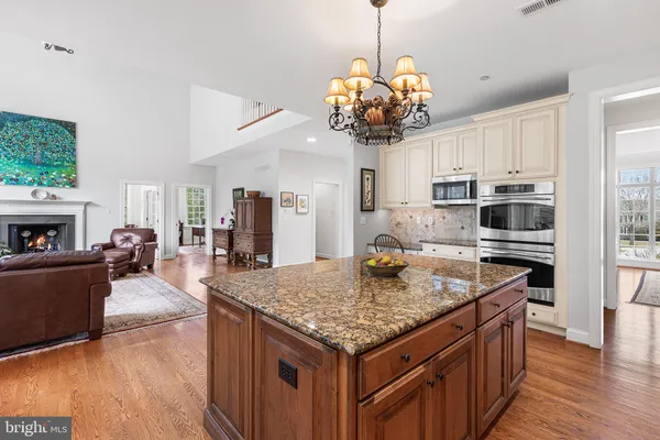 a kitchen with a center island wooden floor and a chandelier
