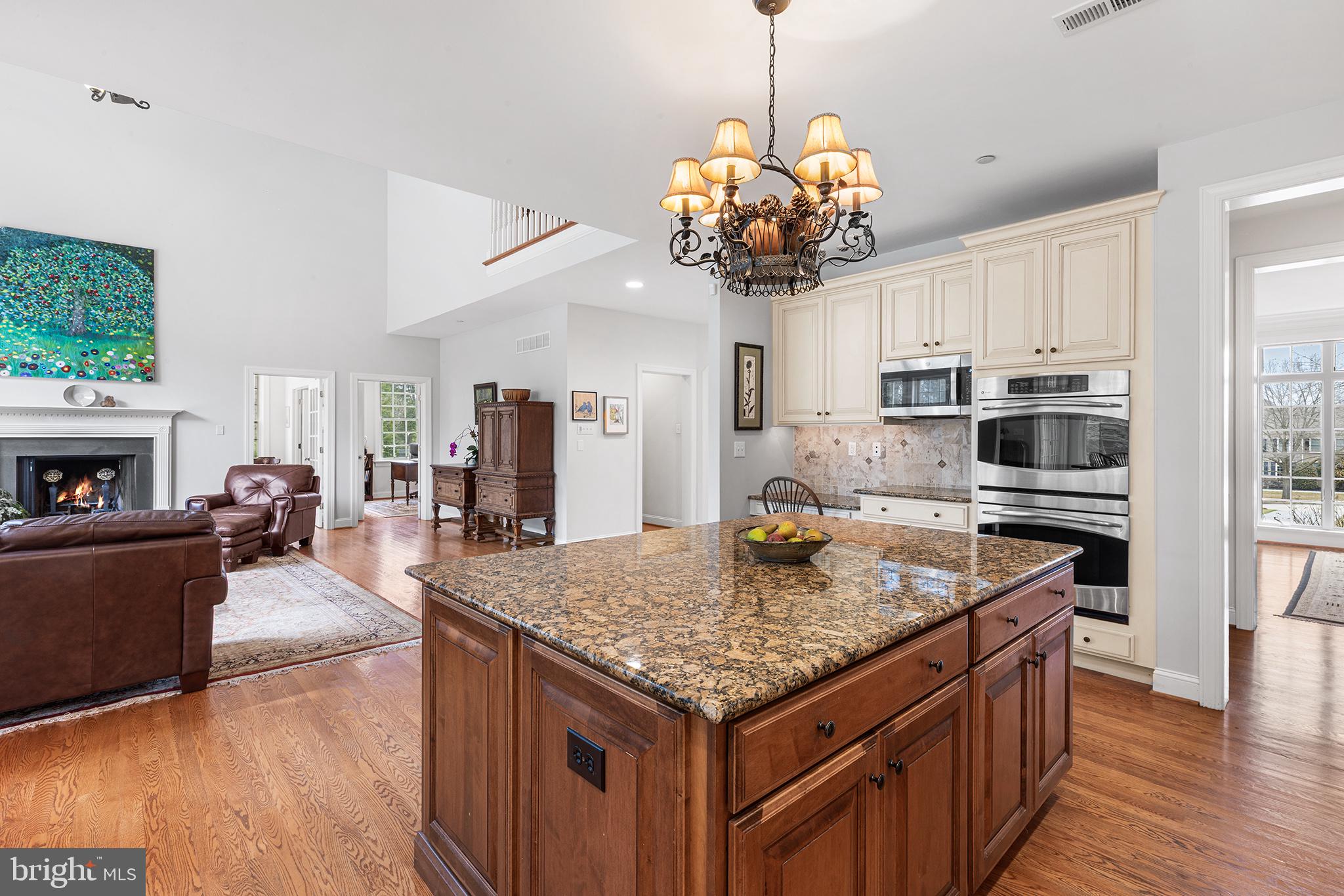 371 Trillium Lane Wayne, PA 19087 - Photo 16 of 43 a kitchen with a center island wooden floor and a chandelier