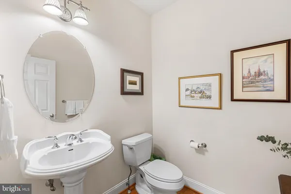 a bathroom with a toilet a sink and mirror