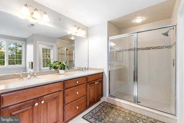 a spacious bathroom with a shower sink and mirror