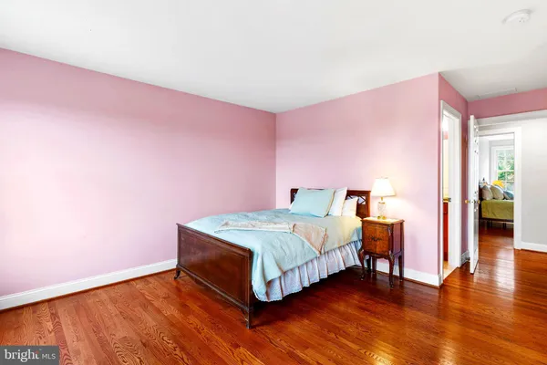 a spacious bedroom with a bed and a wooden floor
