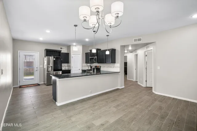 a large white kitchen with a refrigerator a microwave oven a stove and a sink