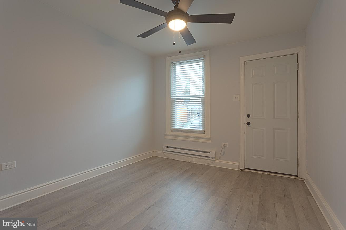 417 North 2nd Street Reading, PA 19601 - Photo 3 of 22 an empty room with wooden floor ceiling fan and windows