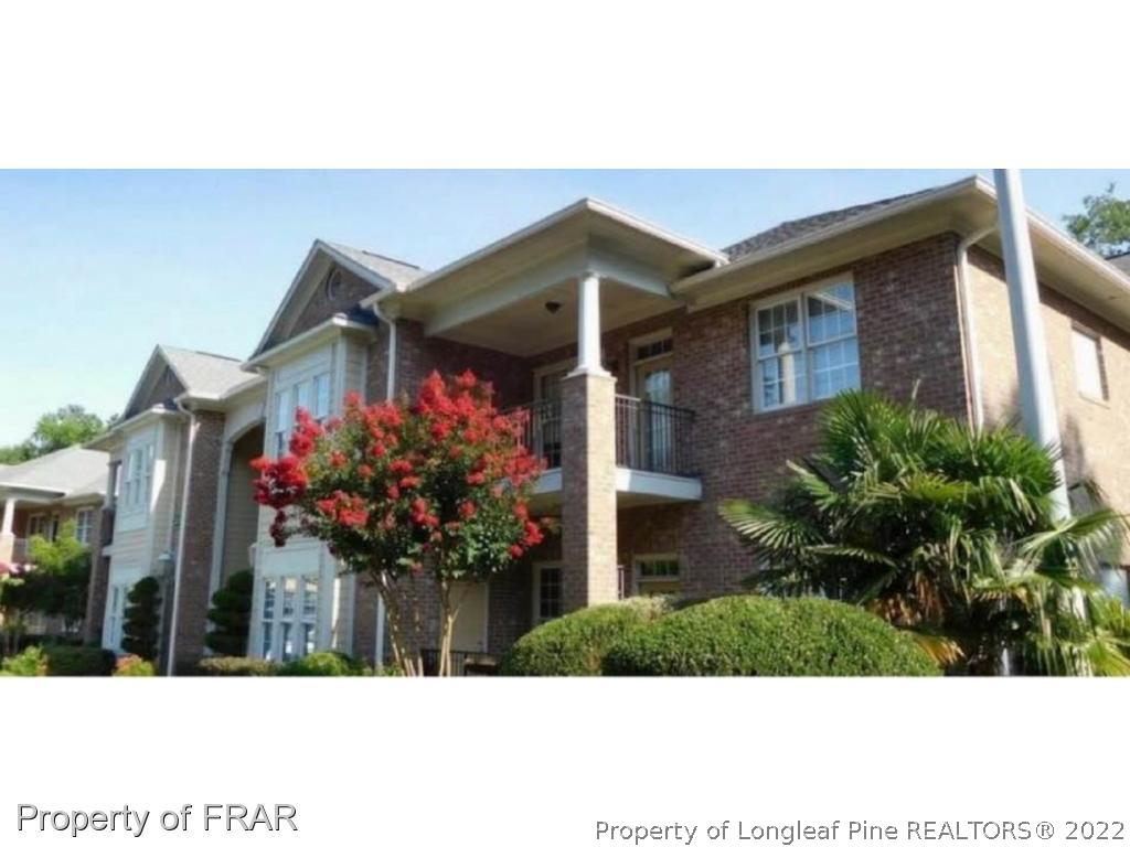 a view of a house with a yard and potted plants