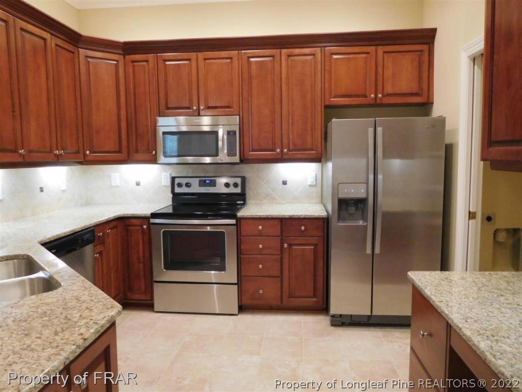 2641 Lockwood Road, Unit 202 Fayetteville, NC 28303 - Photo 13 of 36 a kitchen with granite countertop wooden cabinets and stainless steel appliances