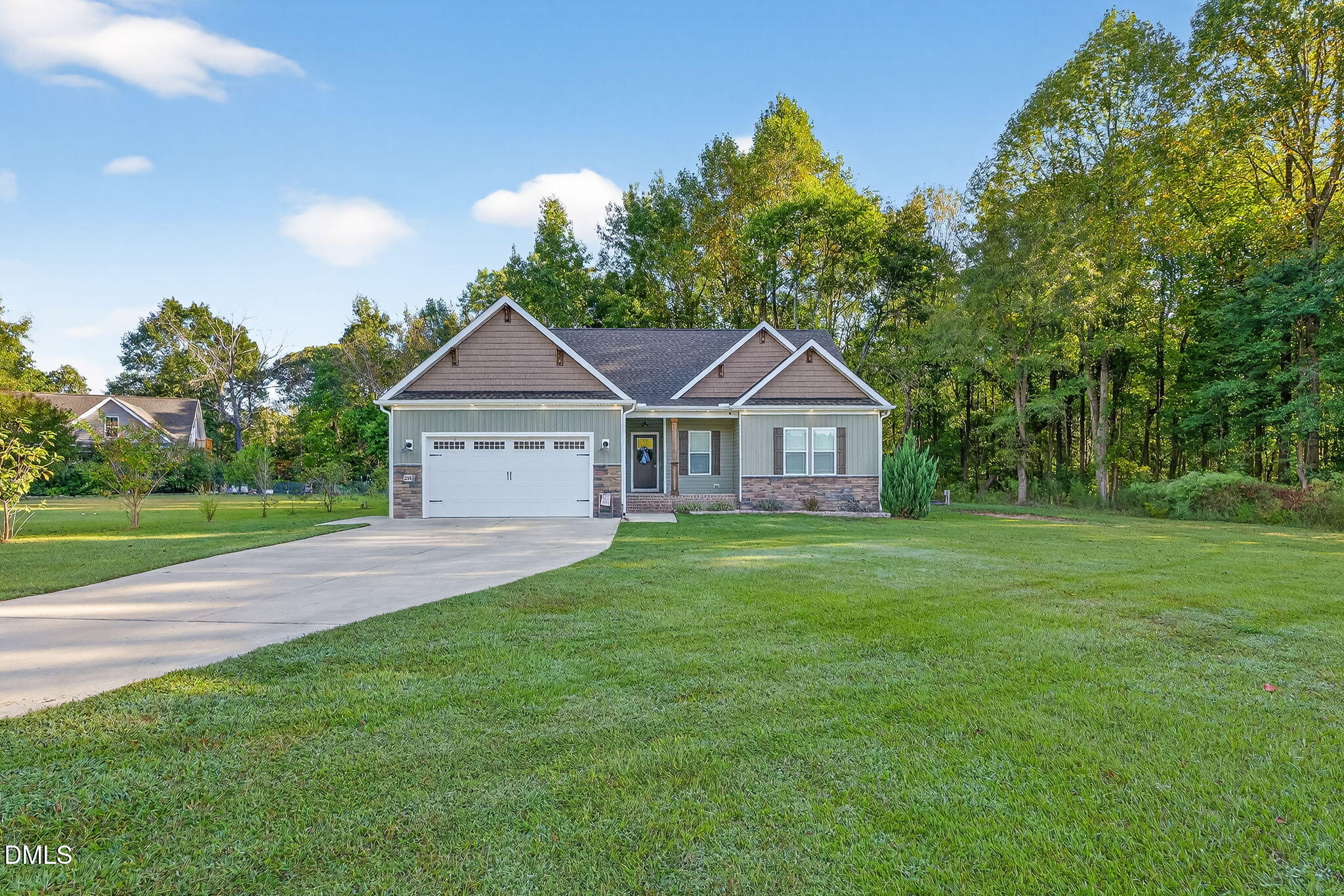 a front view of a house with a yard and trees