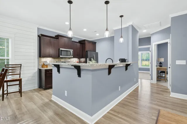 a living room with furniture kitchen view and a chandelier