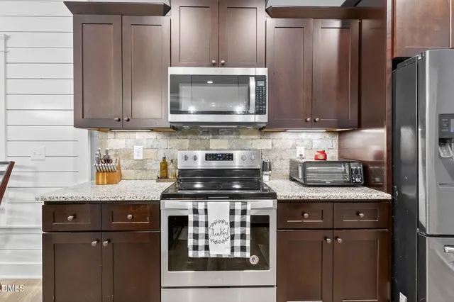 a kitchen with a sink a counter space cabinets and appliances