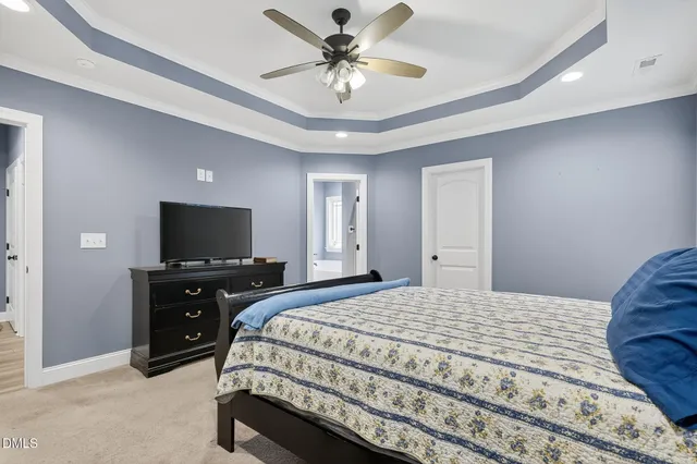 a bed room with a bed and a ceiling fan