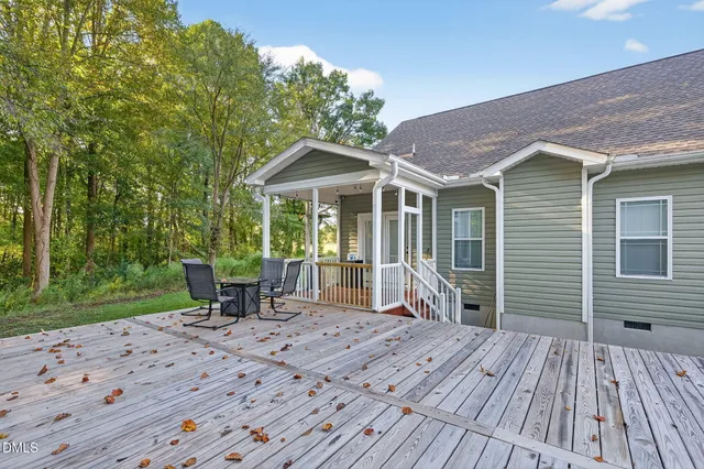 a view of a house with a yard and wooden deck