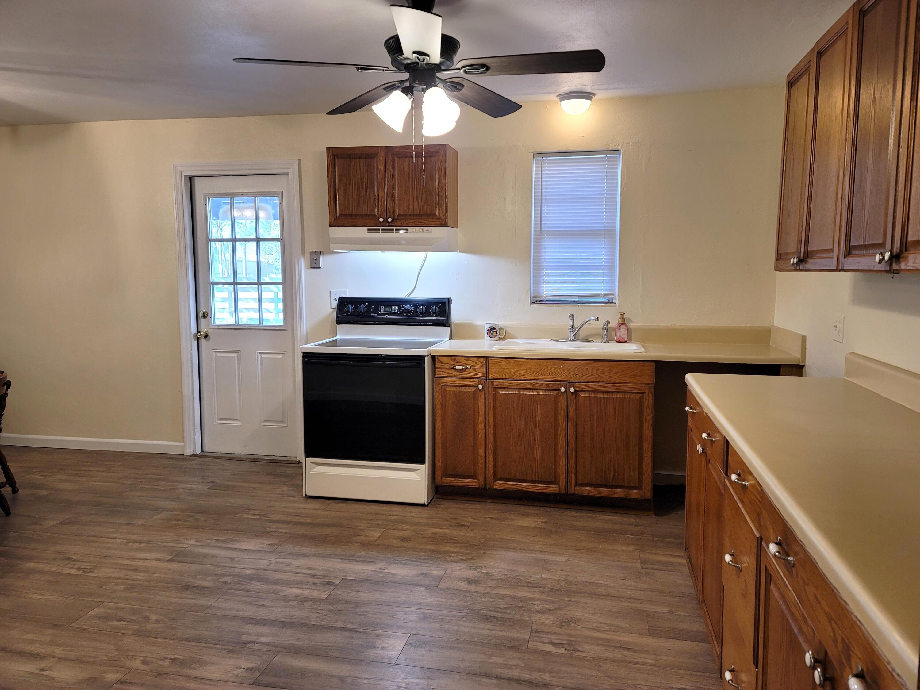 4362 West Midway Road Fort Pierce, FL 34981 - Photo 13 of 31 a kitchen with stainless steel appliances granite countertop a sink a stove a refrigerator cabinets and wooden floor