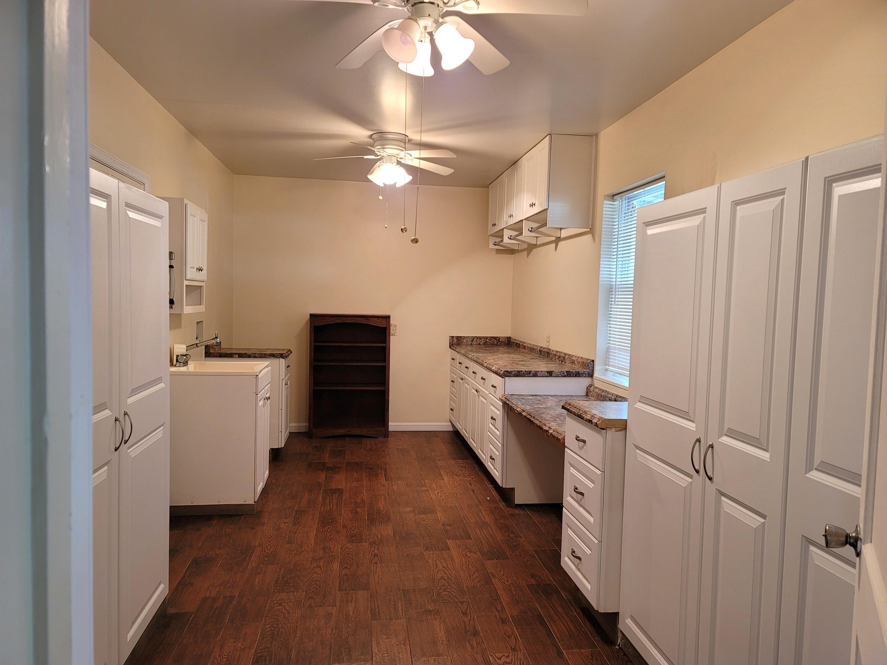 4362 West Midway Road Fort Pierce, FL 34981 - Photo 16 of 31 a kitchen with cabinets and wooden floor