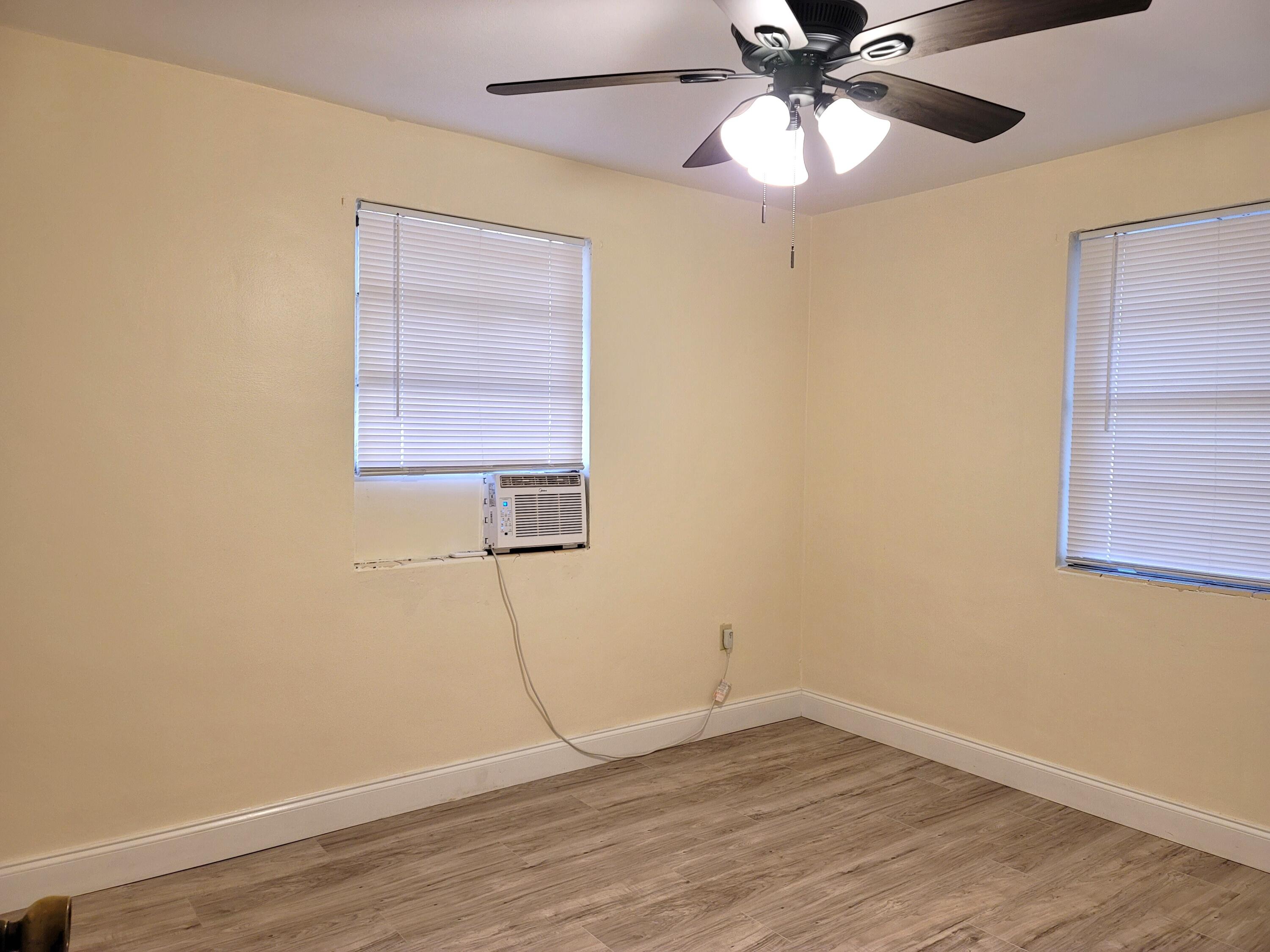 4362 West Midway Road Fort Pierce, FL 34981 - Photo 19 of 31 a view of an empty room with wooden floor and a fan
