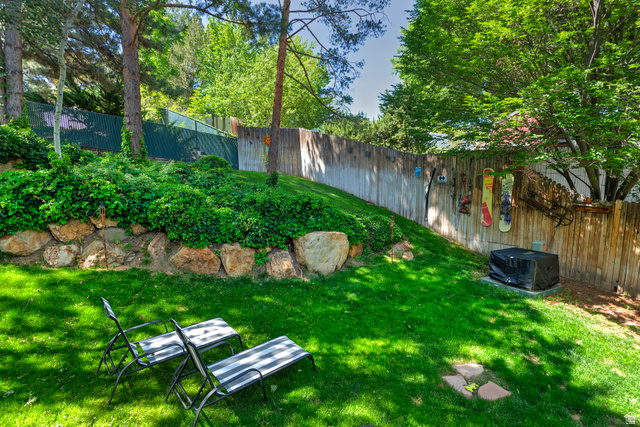 3310 Creek Road Salt Lake City, UT 84121 - Photo 41 of 49 Expansive rear yard featuring a manicured lawn, established landscaping, and mature trees