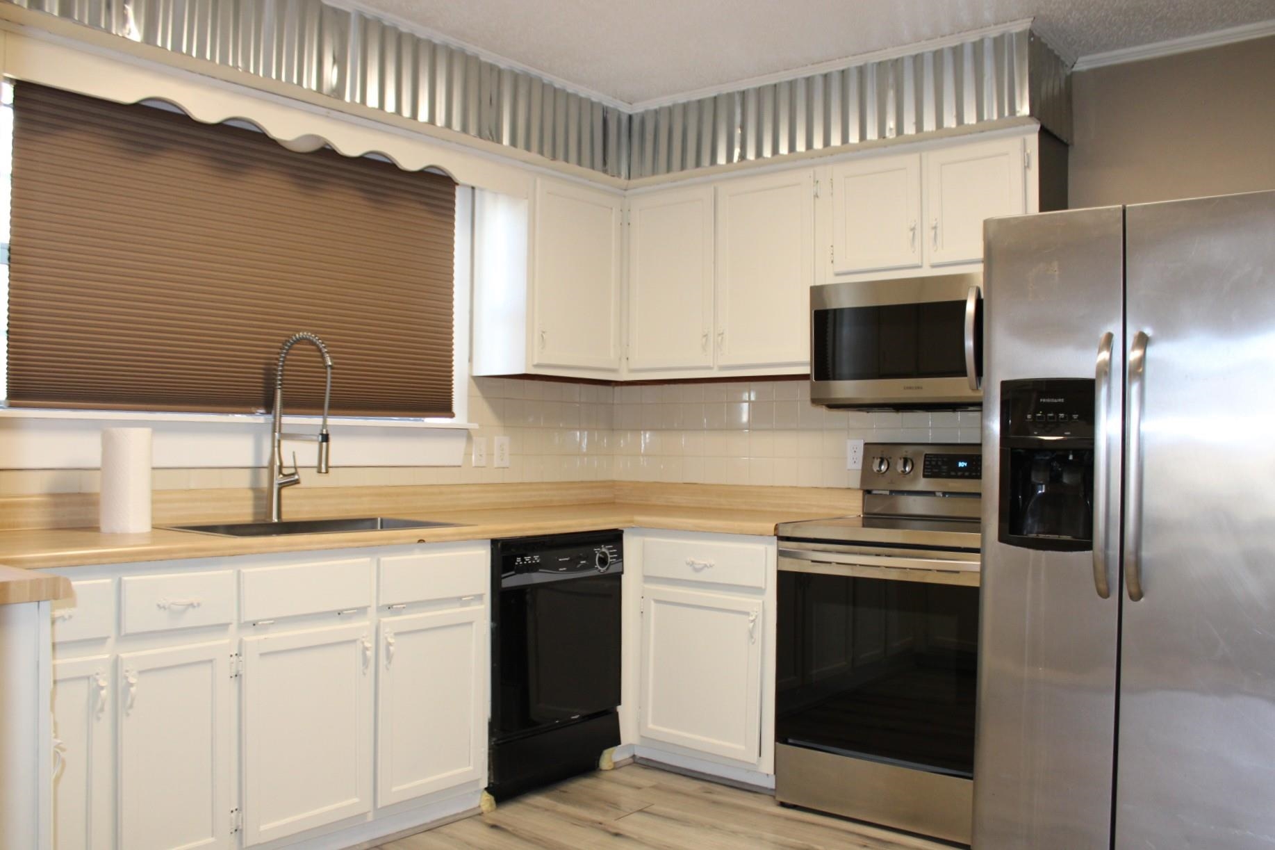 5787 Richardson Landing Road Drummonds, TN 38023 - Photo 4 of 37 a kitchen with a sink stainless steel appliances and cabinets