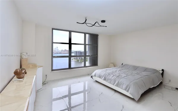 a spacious bedroom with a bed and a large window