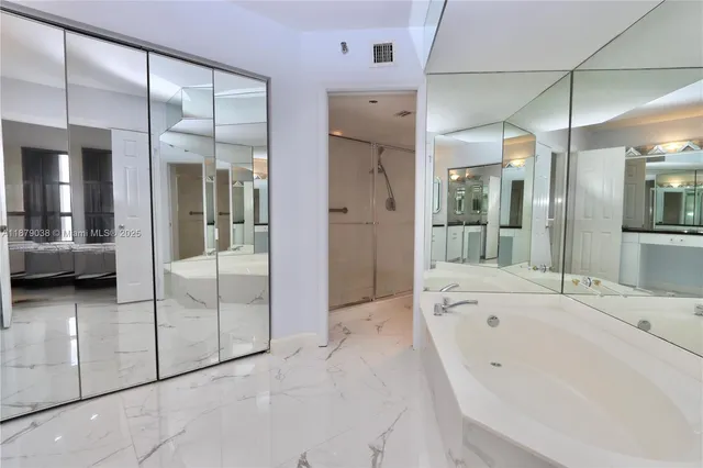 a bathroom with a tub and a glass door shower