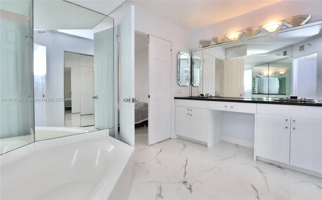 a spacious bathroom with a granite countertop sink mirror and a