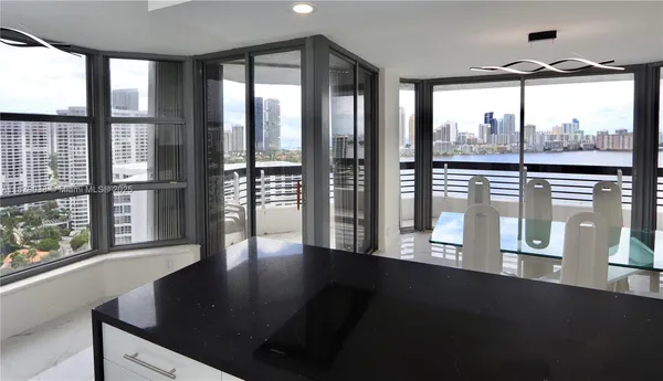 a view of a floor to ceiling window and a kitchen with wooden floor