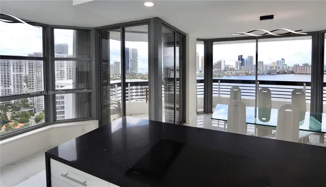 a view of a floor to ceiling window and a kitchen with wooden floor