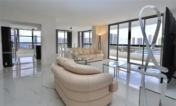 a living room with furniture and a floor to ceiling window