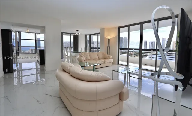 a living room with furniture and a floor to ceiling window