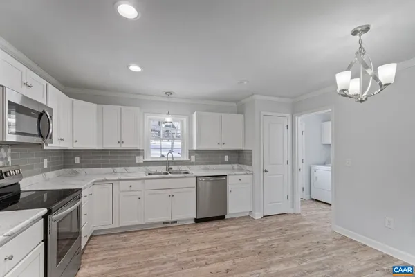 a kitchen with stainless steel appliances granite countertop a sink a stove a refrigerator and cabinets