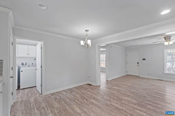 an empty room with wooden floor and mirror