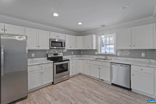 a kitchen with granite countertop white cabinets and white appliances