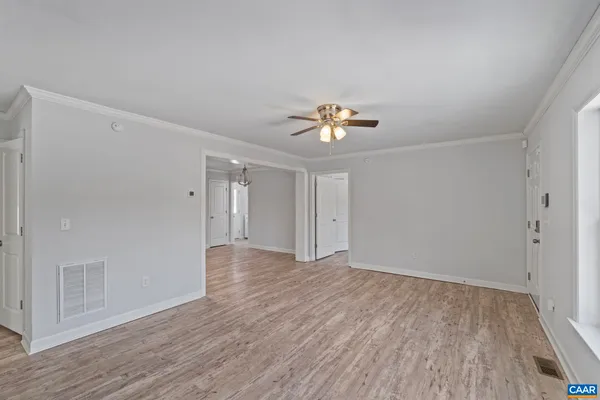 a view of an empty room with wooden floor