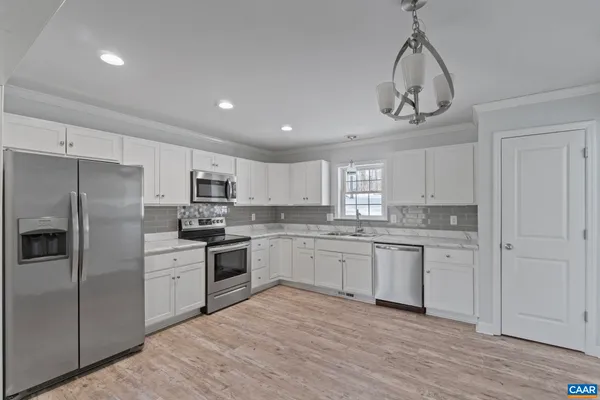 a kitchen with stainless steel appliances granite countertop a sink a stove a refrigerator and cabinets