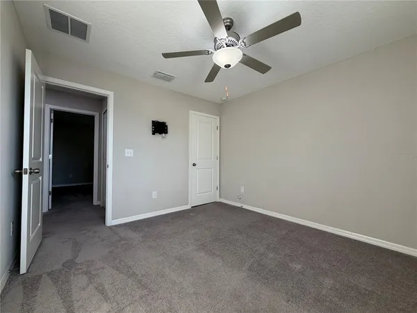 an empty room with fan and a ceiling fan