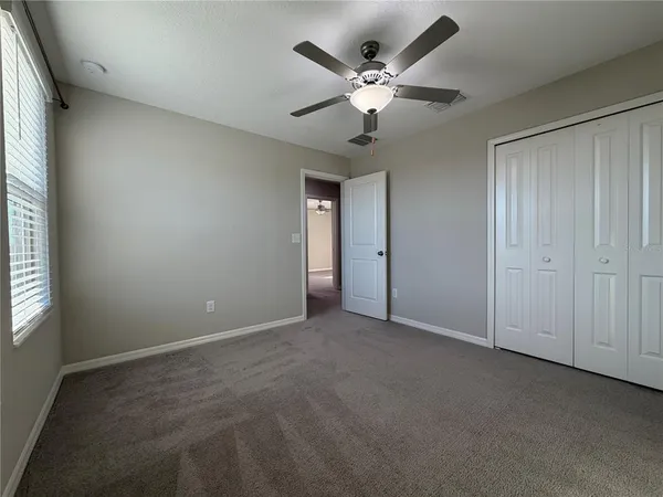 an empty room with chandelier fan