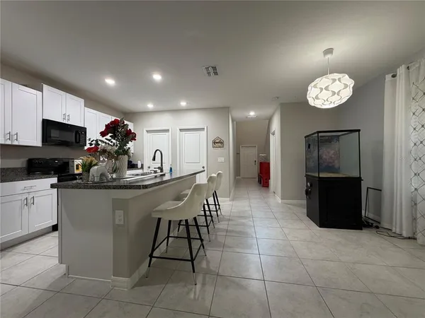 a kitchen with stainless steel appliances granite countertop a sink a microwave and a refrigerator