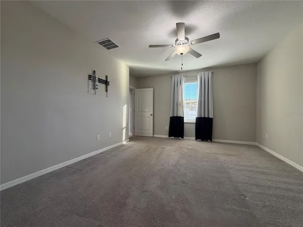 a view of a livingroom with a ceiling fan and window