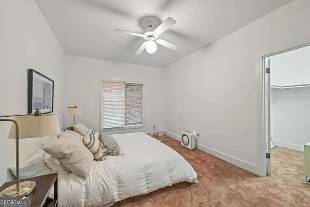 a bedroom with a large bed and a ceiling fan