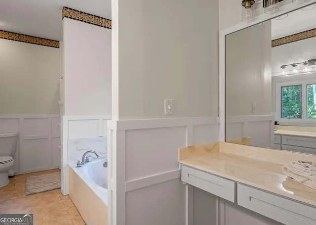 a bathroom with a tub sink and mirror