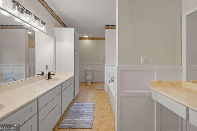 a spacious bathroom with a double vanity sink and mirror