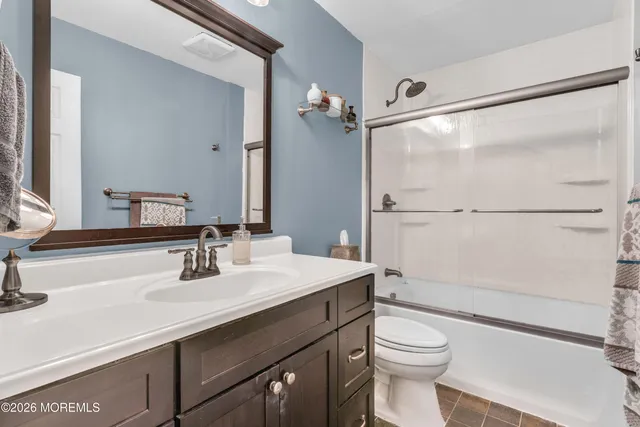 a bathroom with a sink vanity mirror and toilet