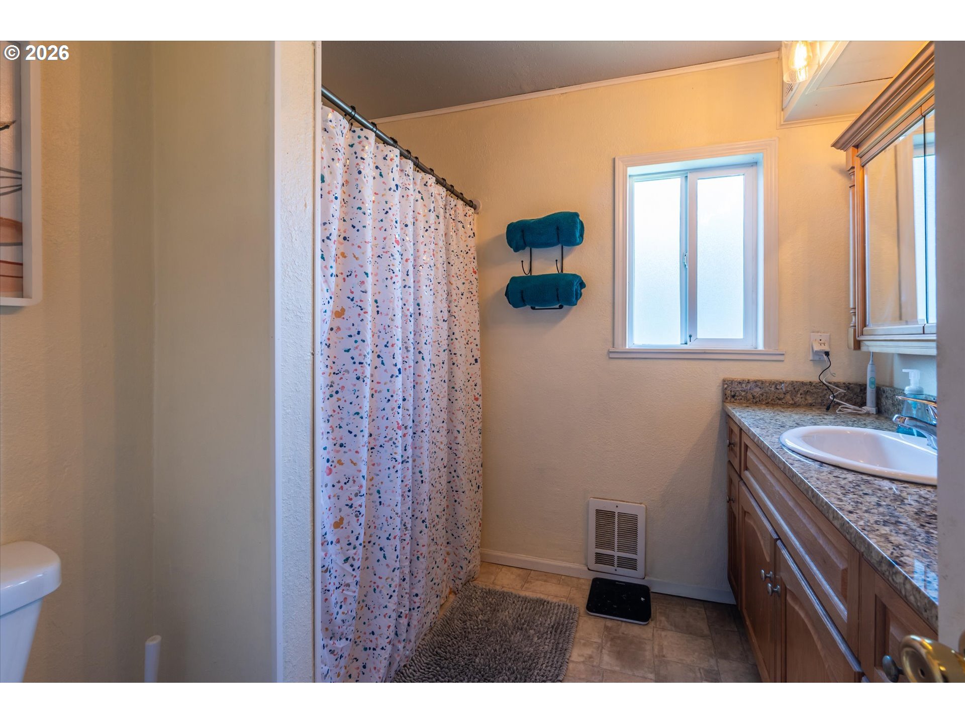 1789 14th Street North Bend, OR 97459 - Photo 32 of 43 a bathroom with a granite countertop sink a toilet and a mirror