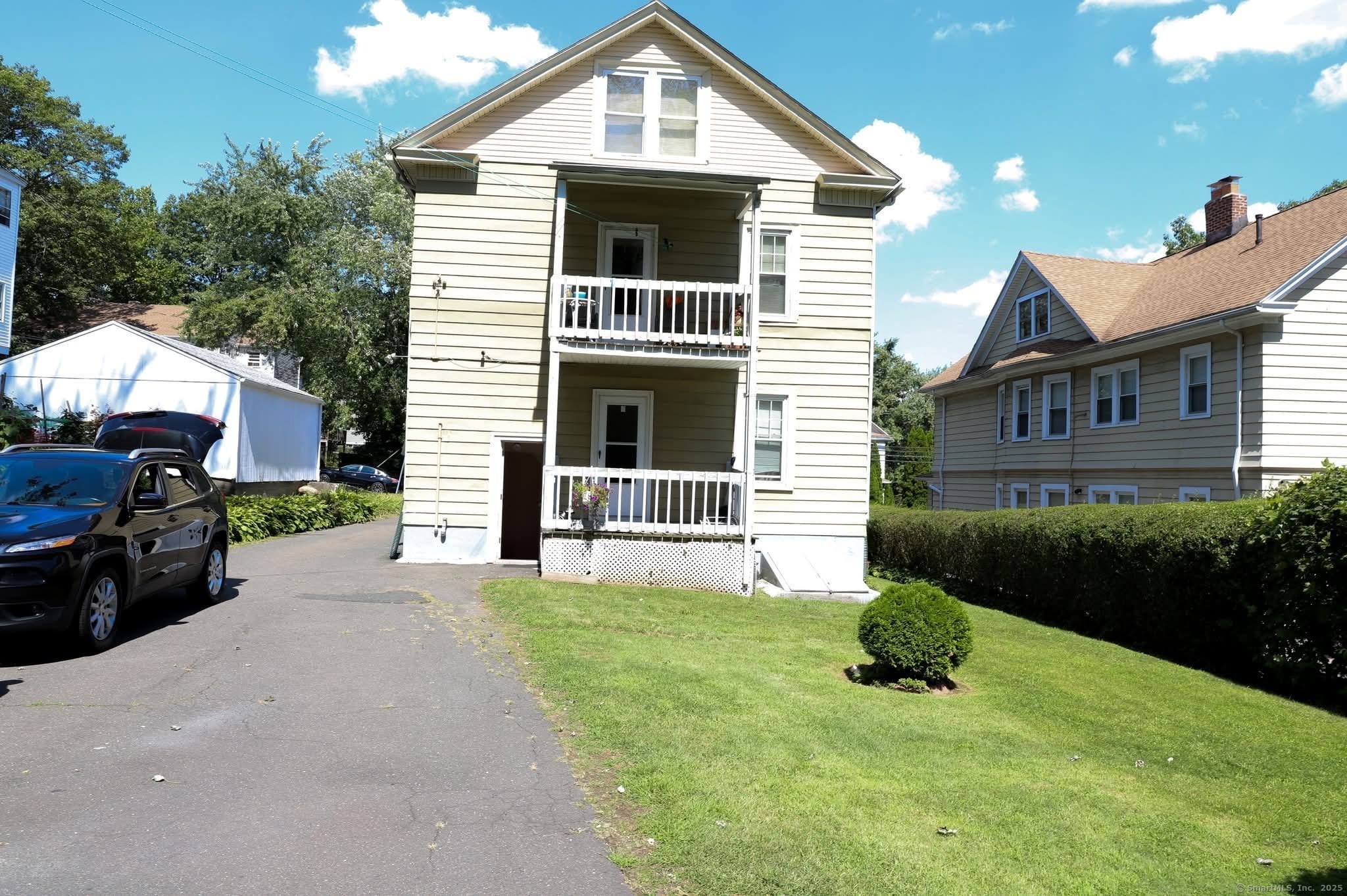 11 Pershing Street Hartford, CT 06112 - Photo 3 of 37 a front view of a house with a yard and garage